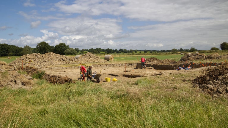 An open trench in a field for an archaeological dig
